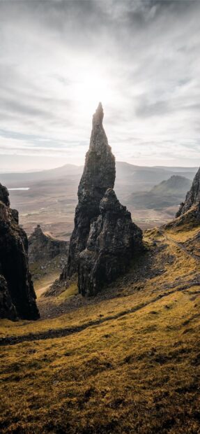 The Isle Of Skye rock formation stands tall on the rugged landscape under cloudy sky
