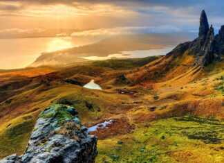 Vast landscape of Isle of Skye with rocky formations and glowing sunlight at sunset