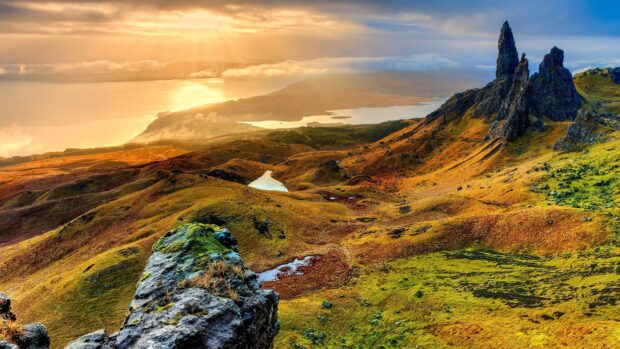 Vast landscape of Isle of Skye with rocky formations and glowing sunlight at sunset