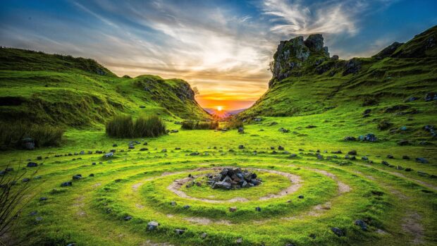 Ancient stone circle in Isle of Skye surrounded by green hills at sunset