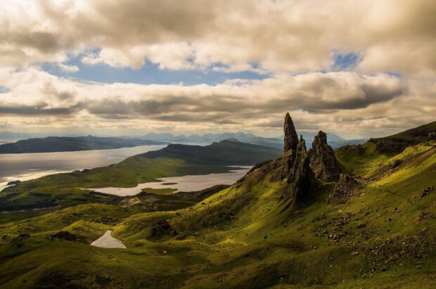 The Isle of Skye landscape with rocky formations and green hills under cloudy sky