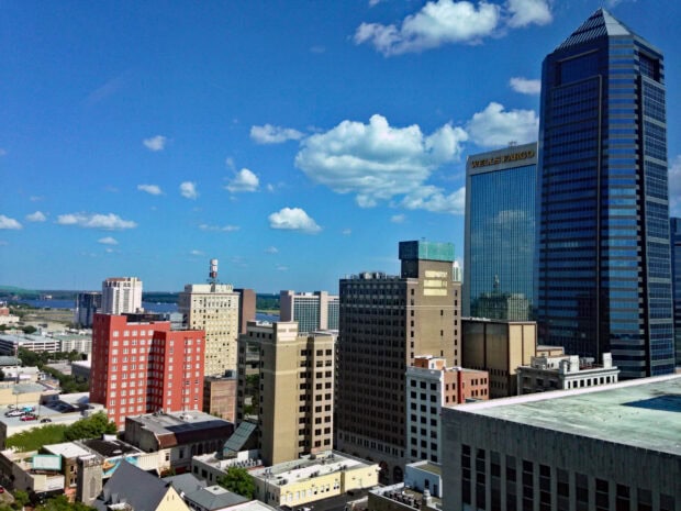 A clear blue sky over the Jacksonville skyline with a focus on the Wells Fargo building and surrounding structures