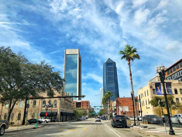 Downtown Jacksonville cityscape with tall buildings and palm trees under blue sky