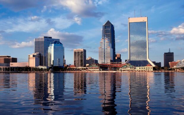 View of Jacksonville city skyline with tall buildings reflecting on calm river water