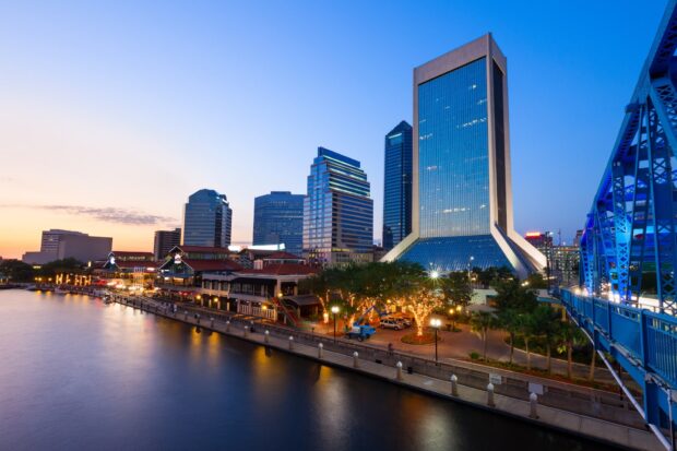 Skyline of Jacksonville with buildings and river at sunset featuring Jacksonville