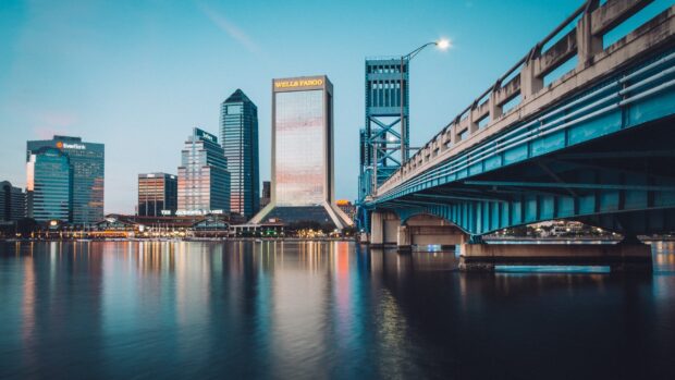 The Jacksonville cityscape with a bridge over the river reflecting skyscrapers at dusk