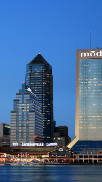 The Jacksonville city skyline with modern buildings at dusk in a clear blue sky