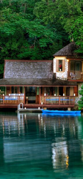 A peaceful Jamaica house surrounded by lush greenery and calm water reflection