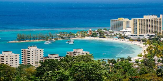 Scenic Jamaica coast with turquoise water and urban buildings on a sunny day