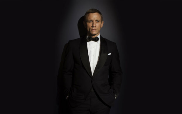 James Bond character wearing a classic black tuxedo in a dark setting