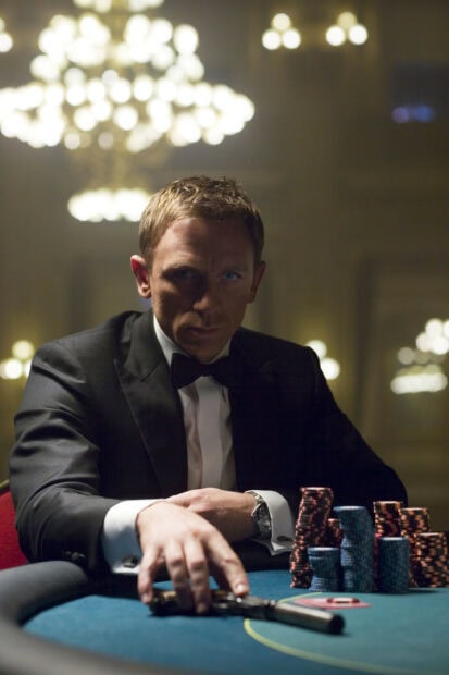 James Bond playing poker with a silenced pistol on the table in a casino room