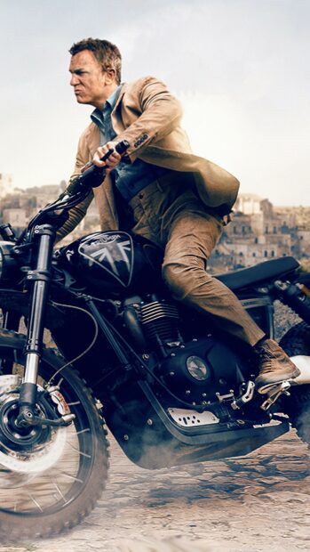 James Bond riding a motorcycle in an action scene with a dusty background