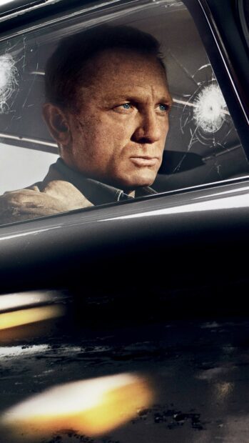 James Bond with intense blue eyes in a car with a cracked window reflecting a tense moment