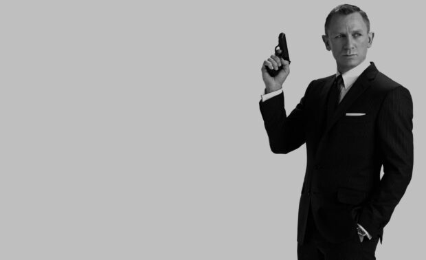 James Bond holding a gun wearing a suit in a James Bond scene