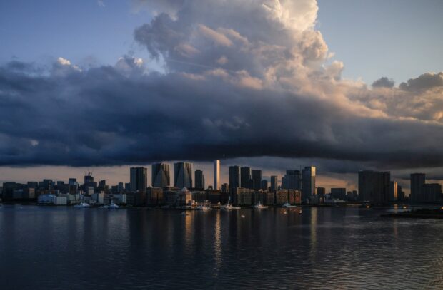 Japan skyline with dramatic clouds over calm water at sunset