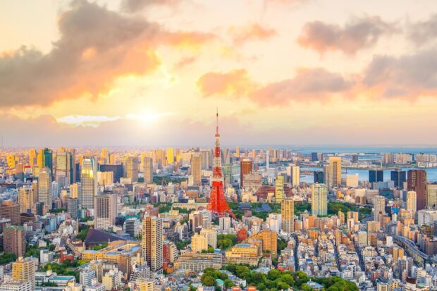 Tokyo tower visible in Japan skyline during a colorful sunset spreading warm light across the cityscape