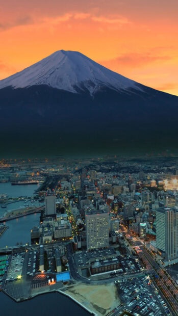 Snow capped Japan skyline at sunset over a vibrant cityscape