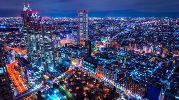 A vibrant Japan skyline with illuminated skyscrapers and busy city streets at night