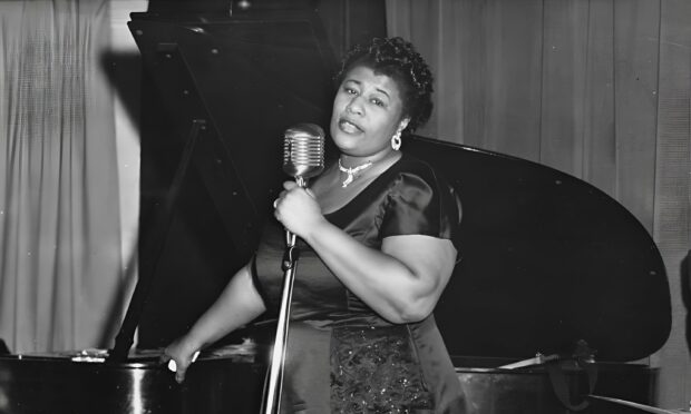 A jazz singer performing passionately in front of a vintage microphone and piano