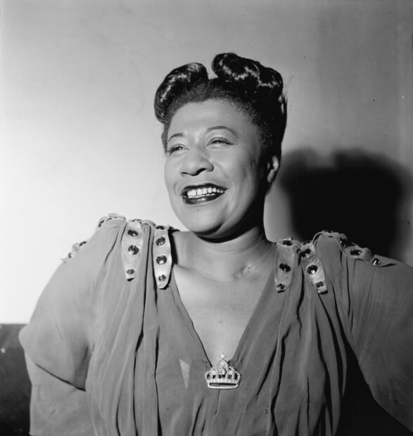Jazz artist smiling brightly in vintage attire with elegant hairstyle and decorative brooch