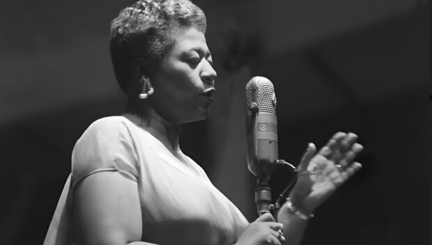 A jazz singer passionately performing with a vintage microphone on stage