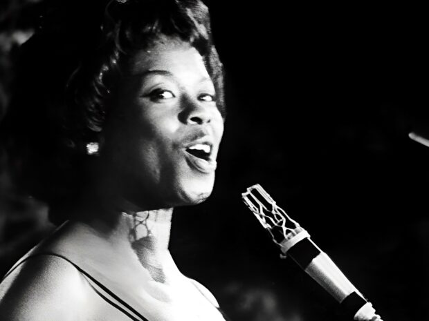 A jazz singer performing passionately with a microphone on stage in black and white lighting