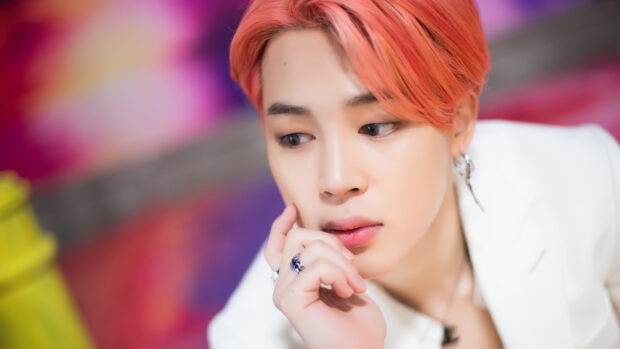 Jimin with vibrant orange hair posing thoughtfully in a close up shot