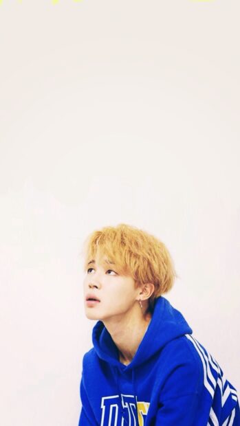 Jimin wearing a blue hoodie looking up with blonde hair against a plain background