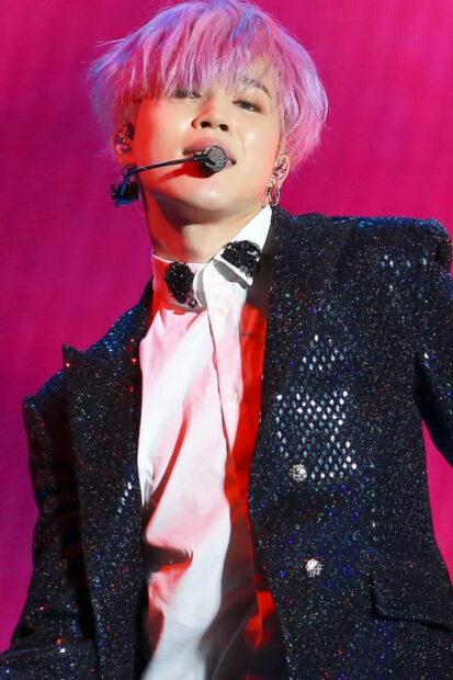 Jimin performing on stage with pink hair and a sparkly black jacket in high quality