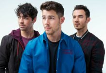 The Jonas Brothers standing together in casual outfits with serious expressions