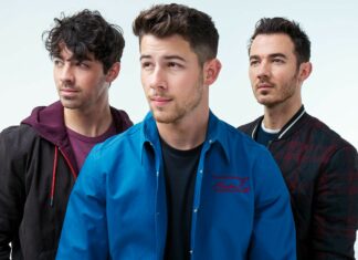 The Jonas Brothers standing together in casual outfits with serious expressions