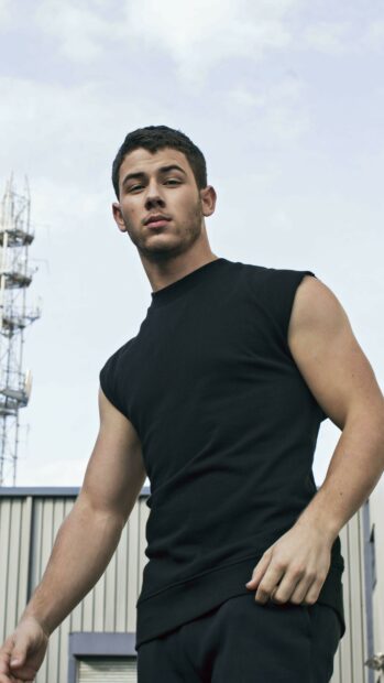 Young man wearing black sleeveless shirt in urban setting Jonas Brothers