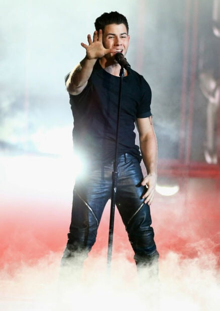 Jonas Brothers vocalist performing on stage with microphone and smoke effects