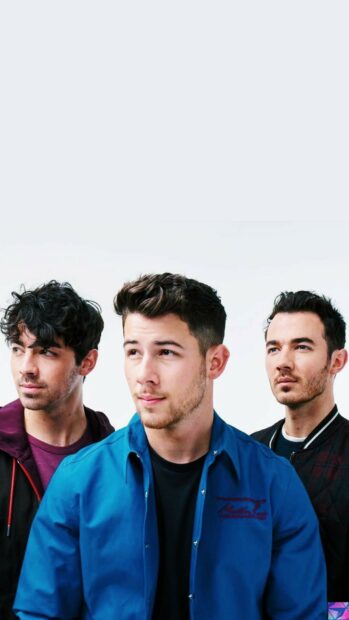 The Jonas Brothers wearing casual clothes looking thoughtfully to the side