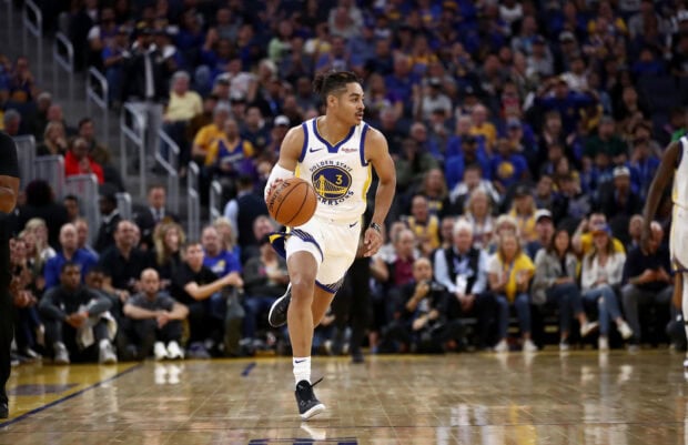 Jordan Poole dribbling the basketball on the court during a game with the Golden State Warriors