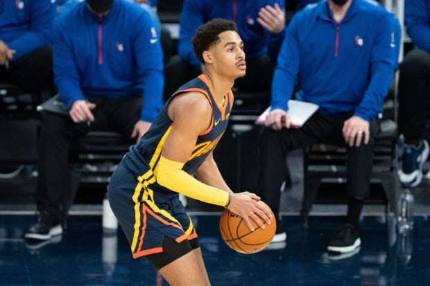 Jordan Poole preparing to shoot a basketball during a game with intense focus on his face