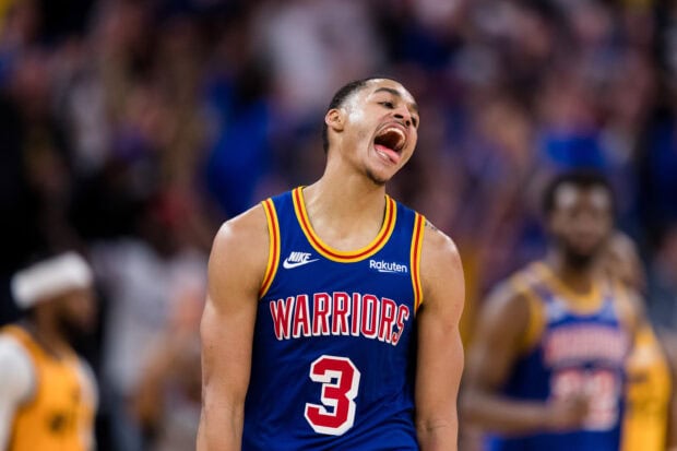 Jordan Poole wearing a Warriors basketball jersey celebrating during a game