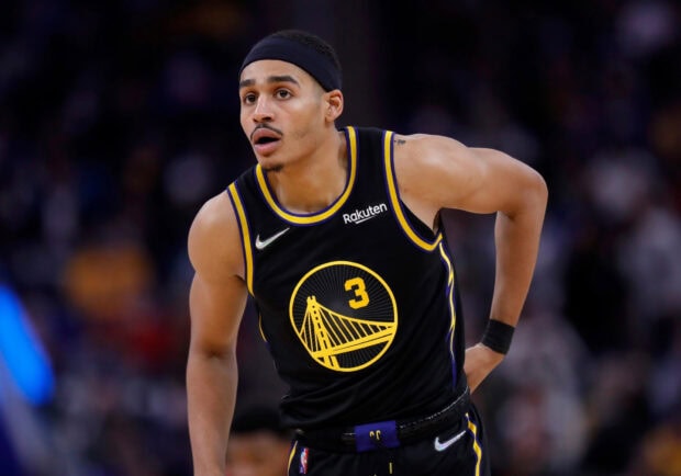 Jordan Poole in a black Golden State Warriors jersey looking focused during a basketball game