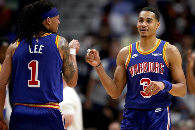 Jordan Poole celebrating with a teammate during a basketball game