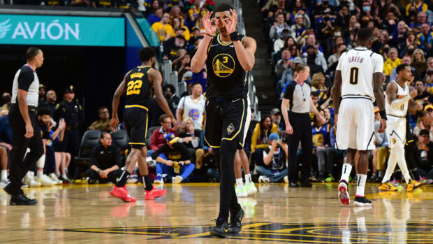 Jordan Poole celebrating on the basketball court during a game in Golden State Warriors uniform
