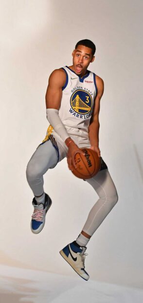 Jordan Poole in Golden State Warriors jersey jumping while holding a basketball