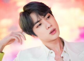 A close up of Jungkook with soft lighting and a colorful background