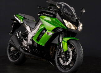 Green Kawasaki sport motorcycle parked on black surface with black background