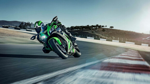 A Kawasaki sport motorcycle leaning into a sharp turn on a race track