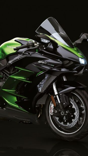 Close up of Kawasaki Ninja motorcycle front wheel and handlebars on black background