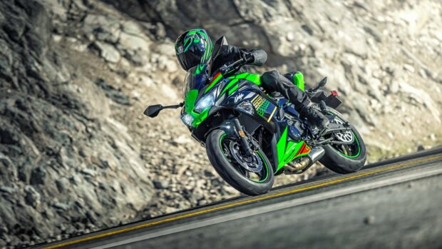 Kawasaki motorcycle leaning into a curve on a mountain road with rocky background