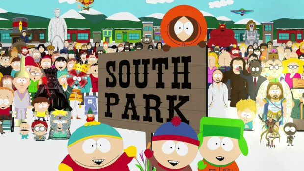 Kenny South Park character wearing an orange hood standing behind a South Park sign in a snowy town scene