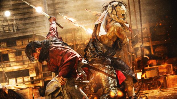Kenshin engaging in intense sword fight with an opponent in a fiery battle scene
