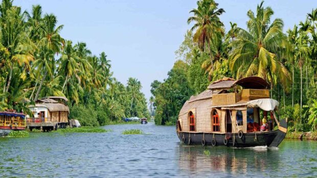 Traditional Kerala houseboat cruising the lush green backwaters of Kerala