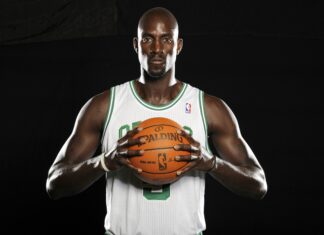 Kevin Garnett holding a basketball wearing a Celtics jersey in a studio setting